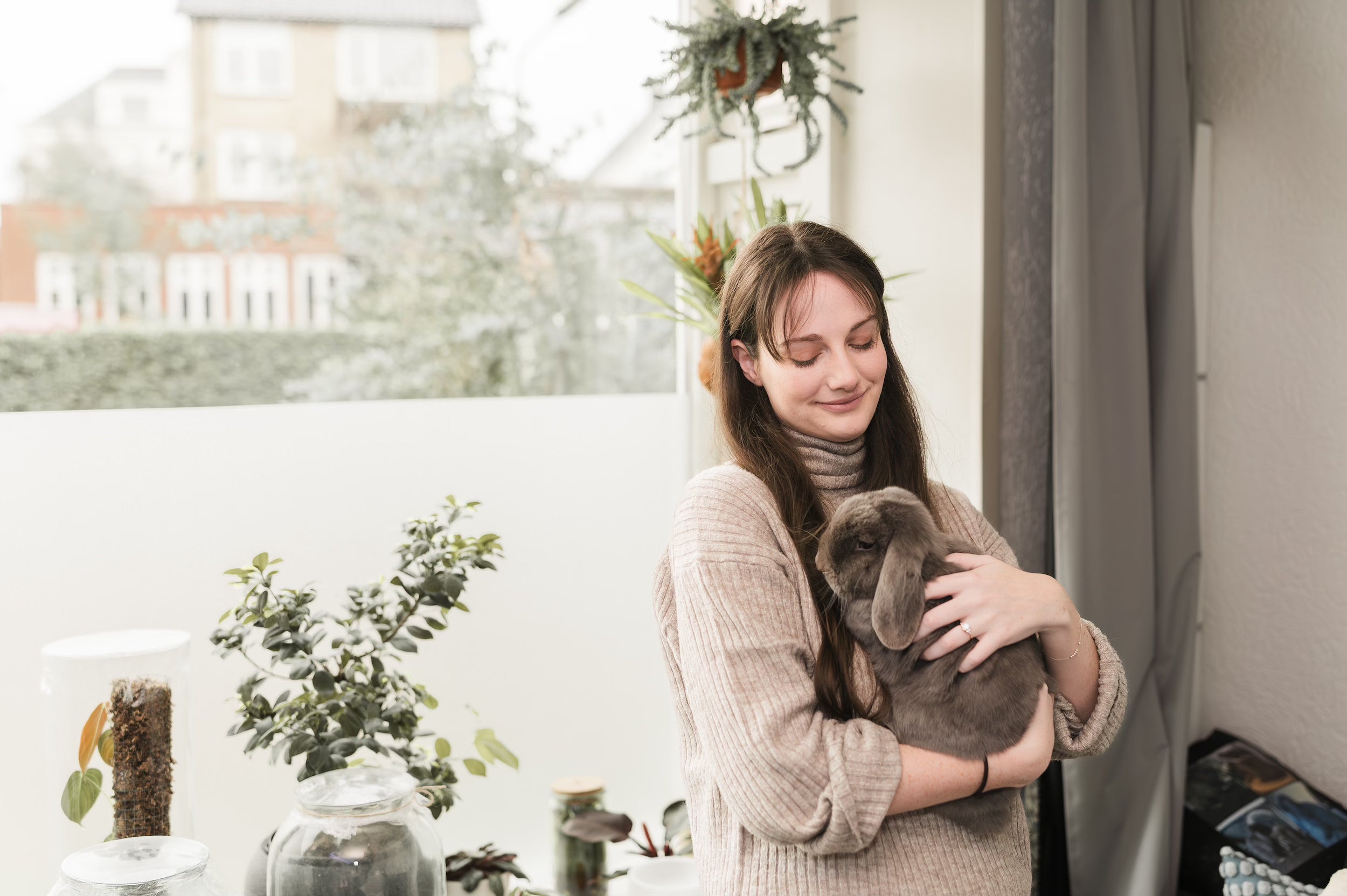Julia Hope holding her beloved bunny, a source of inspiration for her whimsical watercolor animal illustrations and nature-inspired art.